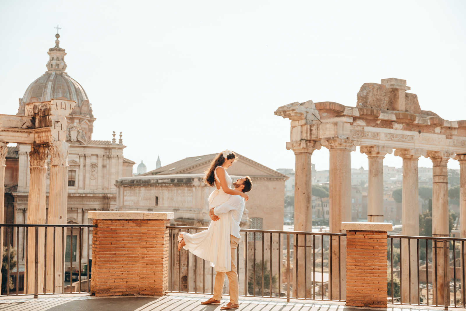 Noivo levantando a noiva em frente das Ruínas do Fórum Romano.